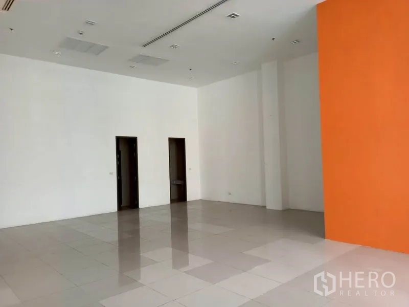 零售空间 出租在Khlong Toei, Bangkok - 开放式商铺，橙色特色墙与两处后区入口。