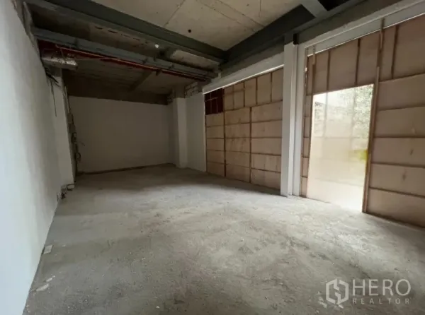 零售空间 出租在Khlong Toei, Bangkok - 店内毛坯空间，水泥地面，临街大窗被木板遮挡。