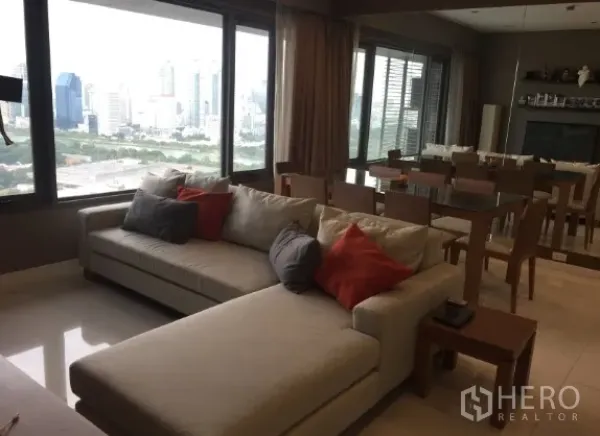 公寓 出租或出售在Sathon, Bangkok - 开放式客餐厅配转角沙发与全景落地窗，尽享城市与公园景观，位于曼谷沙吞公寓。