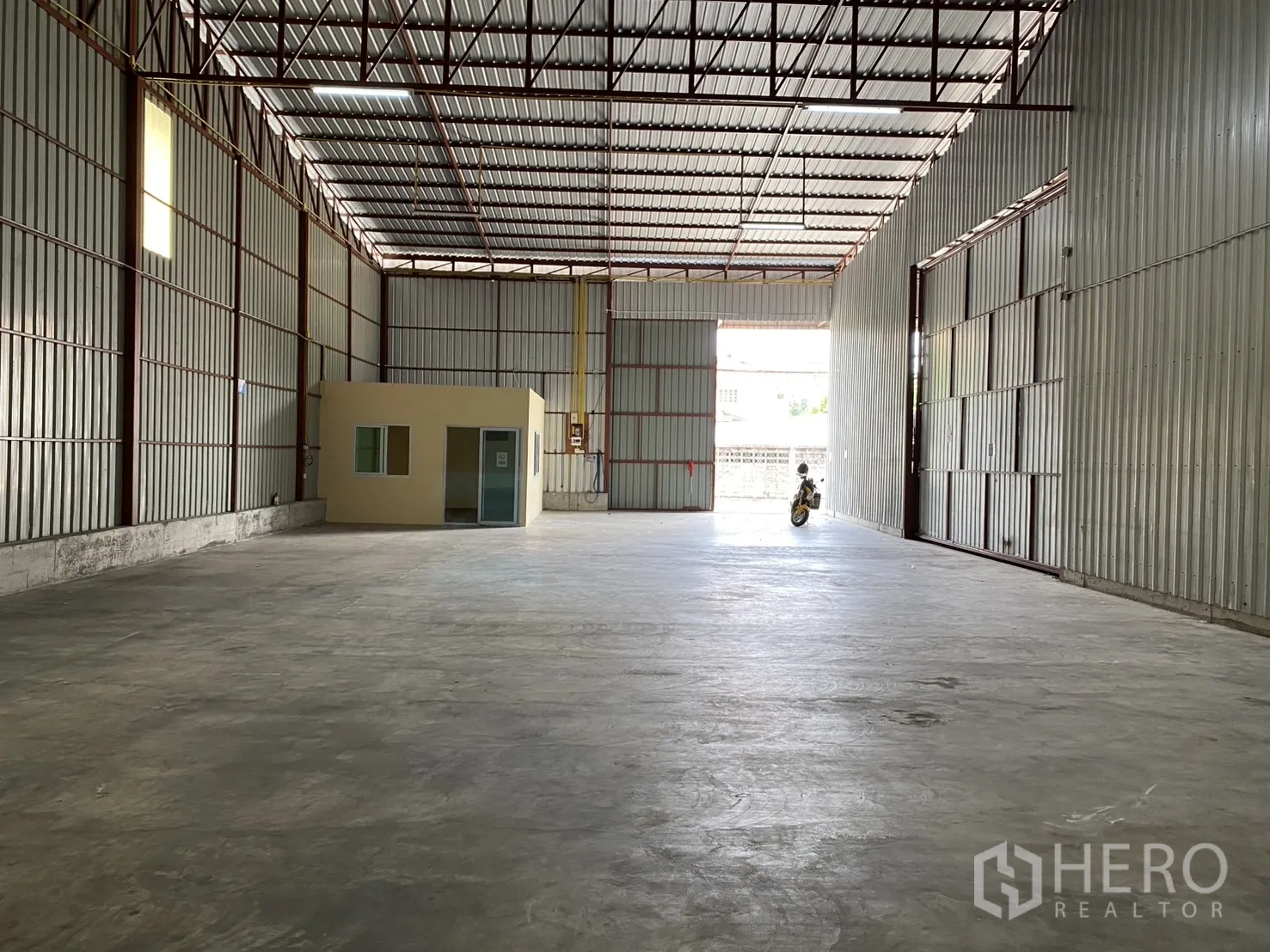 Warehouse for rent in Bueng Kum, Bangkok - View across the warehouse toward the wide loading entrance and office cabin.