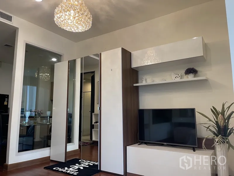 คอนโด ให้เช่าหรือขายในPathum Wan, Bangkok - พื้นที่นั่งเล่นพร้อมตู้เสื้อผ้าบานกระจก ชั้นวางทีวี และชั้นลอยใต้โคมระย้า