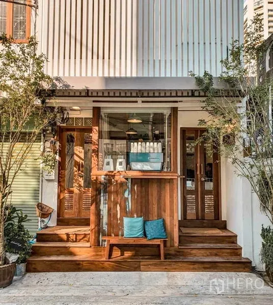 Retail Space for rent in Khlong Toei, Bangkok - Retail storefront with wooden steps, glass doors and a small counter framed by greenery.