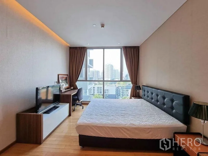 Condominium for rent in Watthana, Bangkok - Bright master bedroom with large window, city view, work desk and TV.