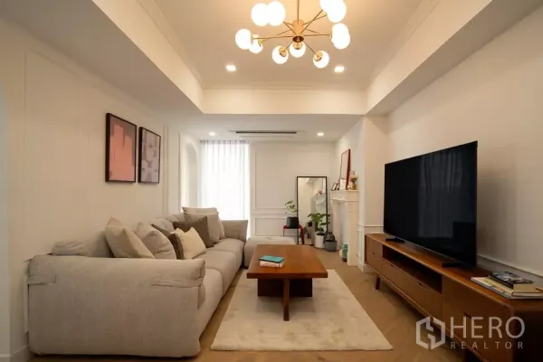 คอนโด ขายในWatthana, Bangkok - ห้องนั่งเล่นสว่างในคอนโดวัฒนา โซฟาขนาดใหญ่ ตู้วางทีวีไม้ โคมไฟโมเดิร์น