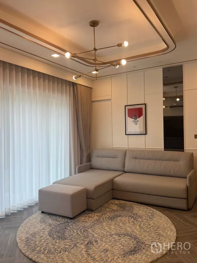 บ้าน ให้เช่าในLat Krabang, Bangkok - ห้องนั่งเล่นโซฟาเข้ามุม พรมกลม และโคมไฟดีไซน์