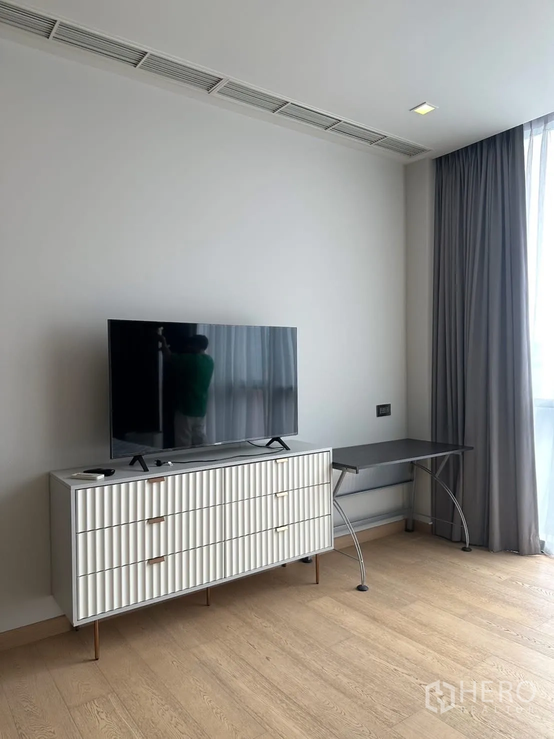 Condominium for rent or sale in Watthana, Bangkok - Bedroom corner with media console, flat-screen TV, and study desk by the window.