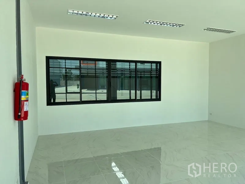 Warehouse for rent in Bang Phli, Samut Prakan - Bright tiled office room with large black-framed window inside the warehouse
