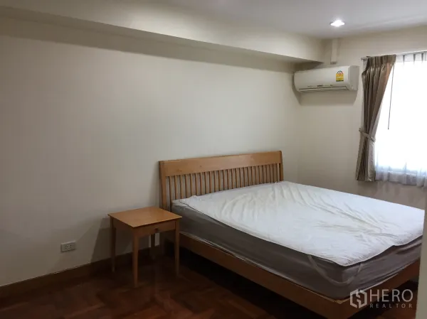 คอนโด ให้เช่าในWatthana, Bangkok - ห้องนอนติดแอร์ เตียงไม้ โต๊ะข้างเตียง และหน้าต่างม่านทึบ
