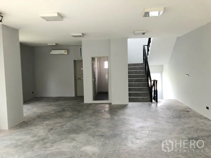 Home Office for rent in Wang Thonglang, Bangkok - Spacious level with staircase, internal bathroom door, air conditioning, and concrete flooring.
