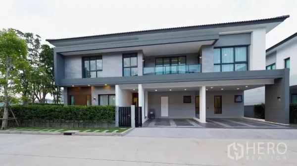 Detached House for rent in Bang Phli, Samut Prakan - Modern two-storey detached house exterior at The City Bangna with balcony and covered carport.