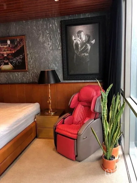 公寓 出租在Watthana, Bangkok - 卧室一角，落地窗、红色按摩椅、床与盆栽