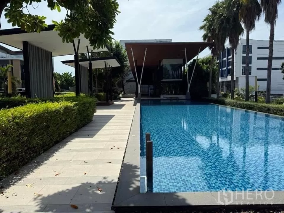 Detached House for rent or sale in Bueng Kum, Bangkok - Estate swimming pool with modern pavilion, palm trees and blue mosaic tiles.