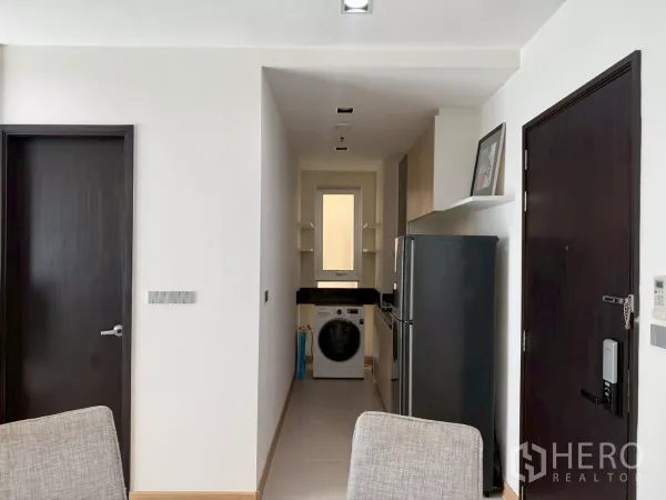 คอนโด ให้เช่าในWatthana, Bangkok - โถงทางเข้าต่อเนื่องไปยังครัวรูปตัวแคบ มีตู้เย็นและเครื่องซักผ้าฝาหน้า