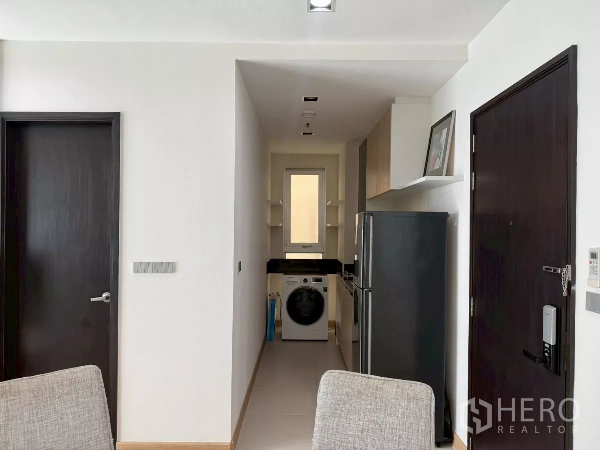 คอนโด ให้เช่าในWatthana, Bangkok - โถงทางเข้าต่อเนื่องไปยังครัวรูปตัวแคบ มีตู้เย็นและเครื่องซักผ้าฝาหน้า