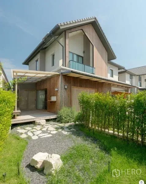 独立式住宅 出售在Bang Phli, Samut Prakan - 现代两层独栋外观，木质立面与阳台，前院绿篱于邦普里