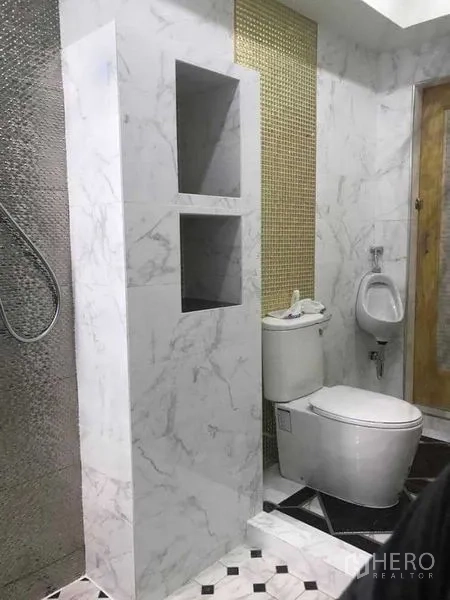 Warehouse for rent in Bang Pakong, Chachoengsao - Modern restroom with marble-style tiles, toilet, urinal and a textured shower wall.