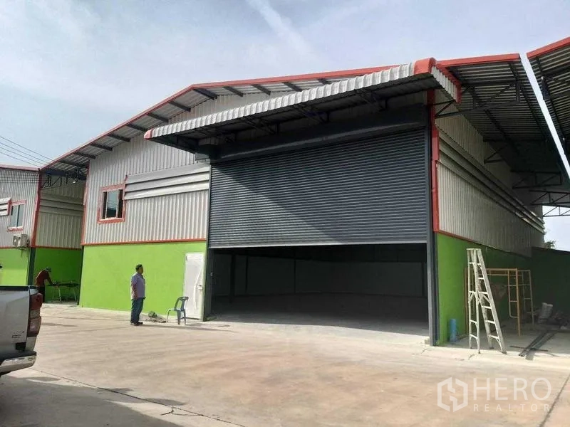Warehouse for rent in Bang Khun Thian, Bangkok - Front view of the warehouse facade with oversized shutter and parking apron.