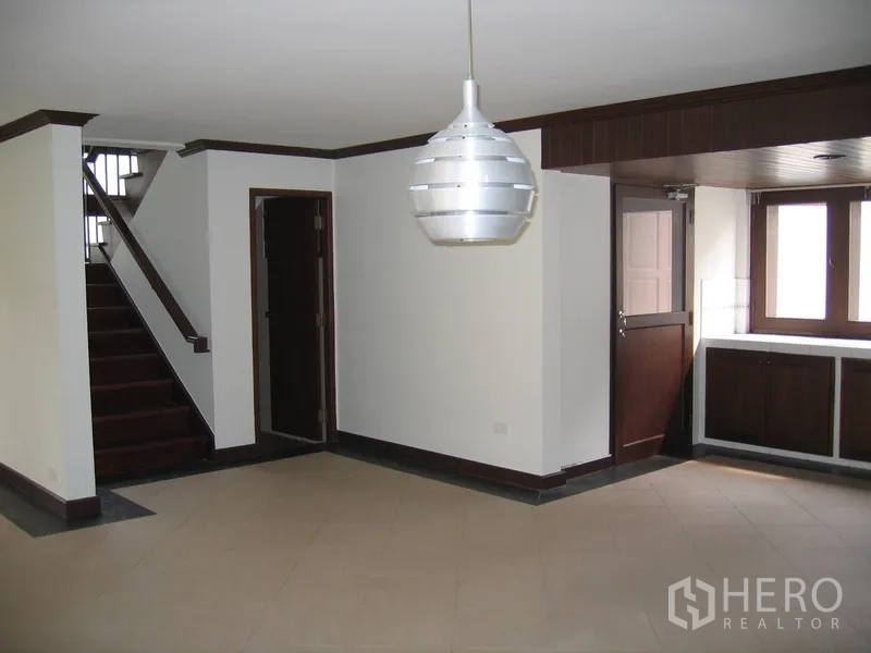 บ้าน ให้เช่าในWatthana, Bangkok - พื้นที่รับประทานอาหารมีโคมไฟแขวน บันได และประตูไม้