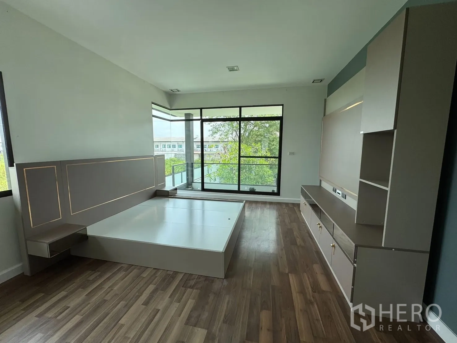 Detached House for rent in Prawet, Bangkok - Bedroom from another angle showing built-in console and leafy balcony outlook.