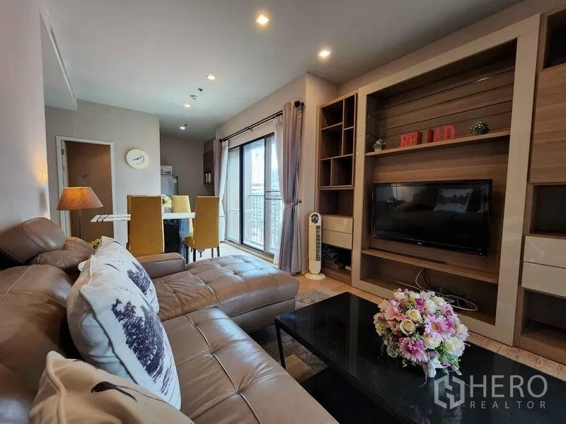 คอนโด ให้เช่าในBangkok - พื้นที่รับแขกและทานอาหารแบบเปิดโล่ง พร้อมโซฟา ชุดทีวี และวิวระเบียง