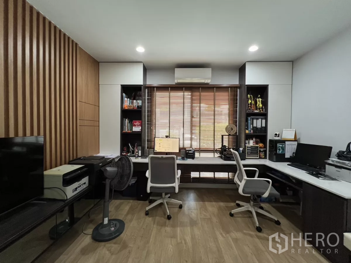 Detached House for rent or sale in Bang Kapi, Bangkok - Home office with two workstations, storage shelves and wood accent wall.