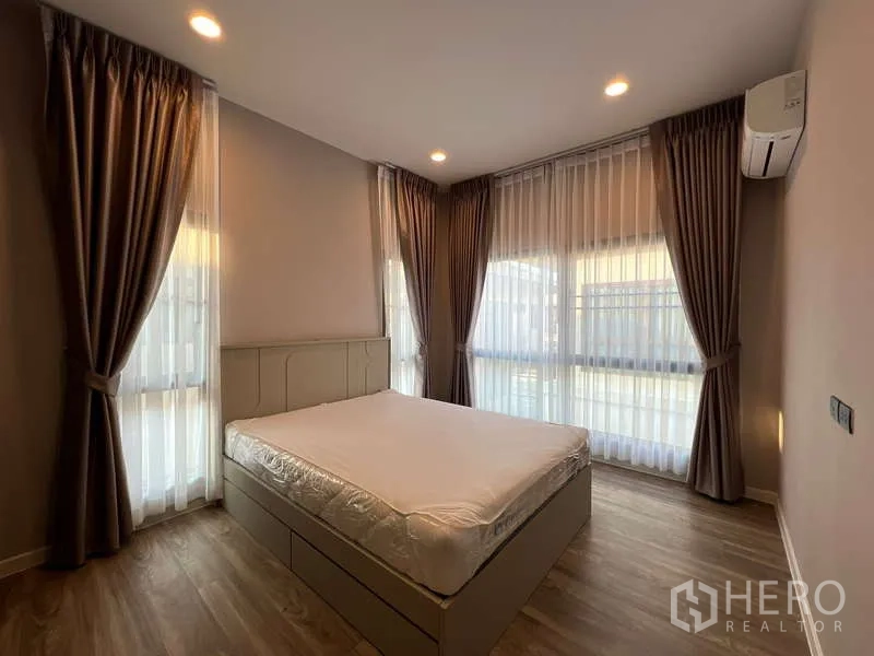 บ้าน ให้เช่าในBang Kapi, Bangkok - ห้องนอนมุมบ้าน มีหน้าต่างบานใหญ่ ผ้าม่านสองชั้น และแอร์