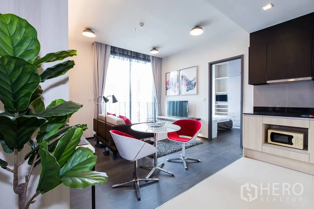 Condominium for rent in Watthana, Bangkok - Compact kitchen and dining set adjoining living room and bedroom entrance.