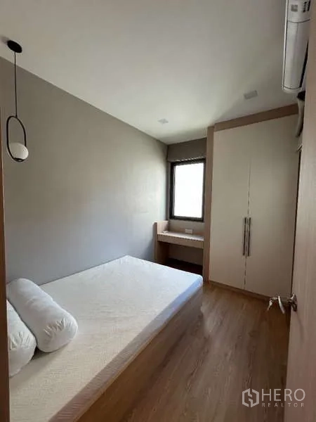 Detached House for rent in Saphan Sung, Bangkok - Compact bedroom with built-in wardrobe, small desk and wood flooring.