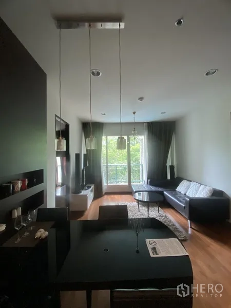 คอนโด ให้เช่าในPathum Wan, Bangkok - พื้นที่นั่งเล่นและรับประทานอาหารแบบเปิด โต๊ะสีดำ โซฟา ตู้ทีวี พื้นไม้ และประตูระเบียงมองวิวต้นไม้