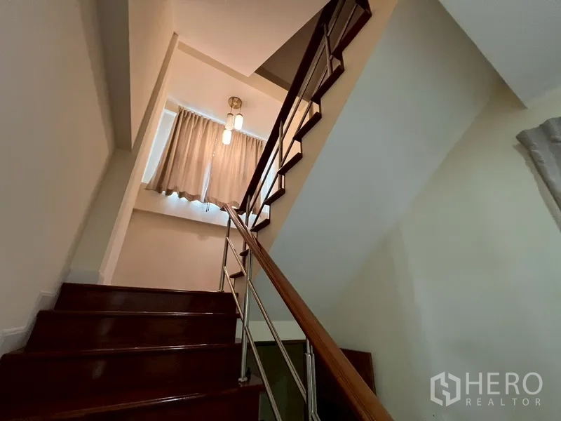 บ้าน ขายในPhra Khanong, Bangkok - บันไดไม้พร้อมราวสแตนเลสและแสงธรรมชาติจากหน้าต่าง