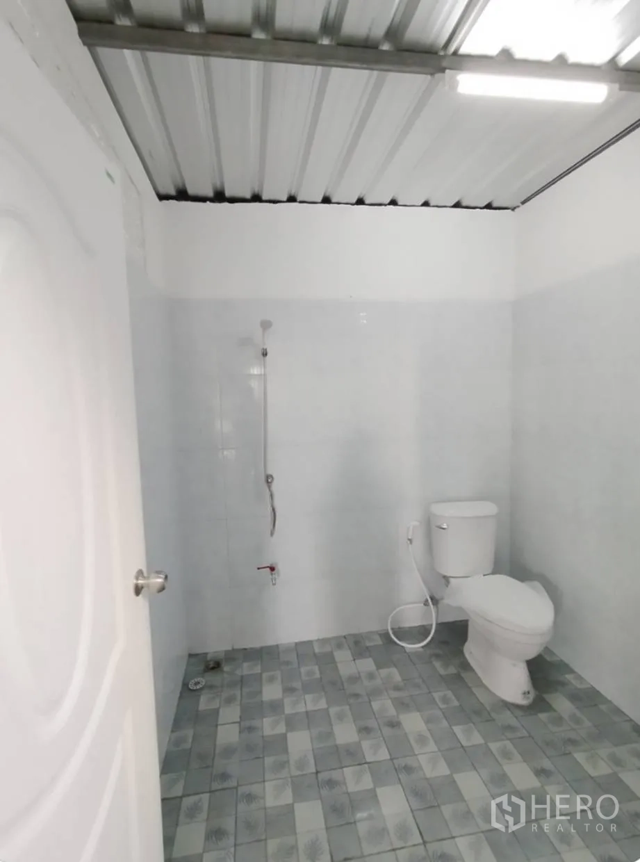 仓库 for rent in Bang Khen, Bangkok - 仓库内独立卫生间，白色瓷砖墙面，手持花洒与坐便器，拼花地砖。