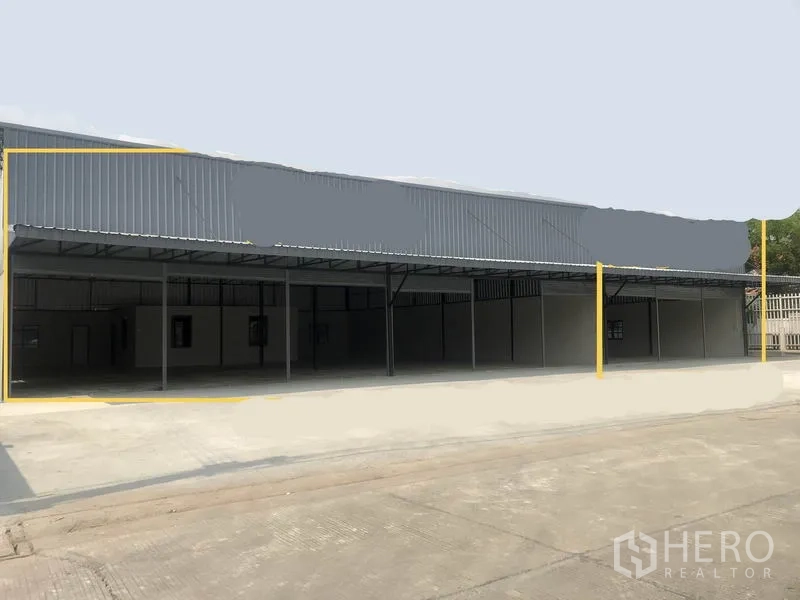 Warehouse for rent in Pathum Thani - Street-facing row of metal-clad warehouses with wide driveway and covered loading bays.