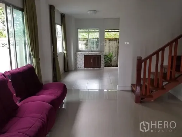 联排别墅 出租在Bang Kapi, Bangkok - 采光明亮的客厅，紫色沙发、瓷砖地面与木楼梯