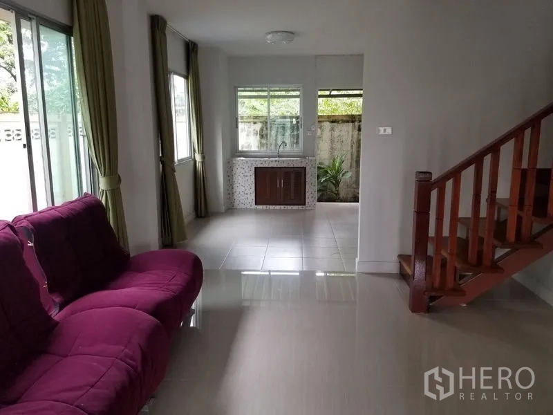 联排别墅 出租在Bang Kapi, Bangkok - 采光明亮的客厅，紫色沙发、瓷砖地面与木楼梯