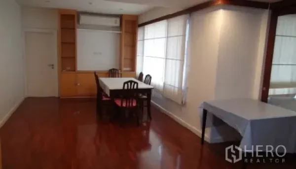 Condominium for rent or sale in Sathon, Bangkok - Bright dining area with table, built-in cabinetry, air conditioner, and large corner windows with sheer curtains.