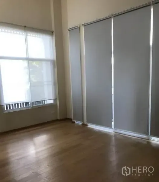 Detached House for sale in Suan Luang, Bangkok - Living area with floor-to-ceiling windows, roller blinds and warm wood flooring.