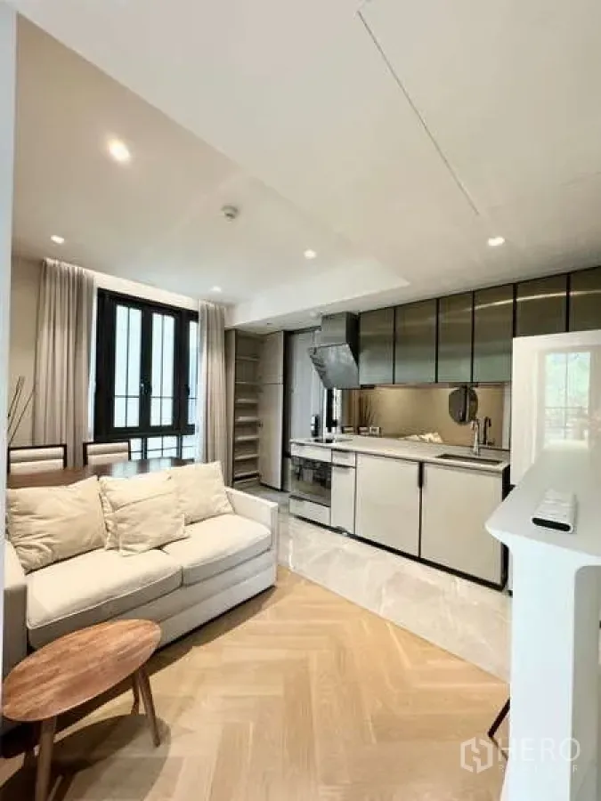 Condominium for rent in Watthana, Bangkok - Open-plan living area featuring a compact kitchen and abundant natural light.