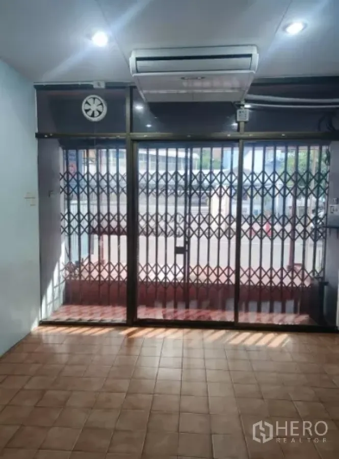 零售空间 出租在Watthana, Bangkok - 一层店面内景，瓷砖地面，玻璃门面配金属拉闸门