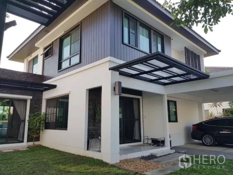 Detached House for rent in Bang Phli, Samut Prakan - Modern two-storey house exterior with covered carport and large windows.