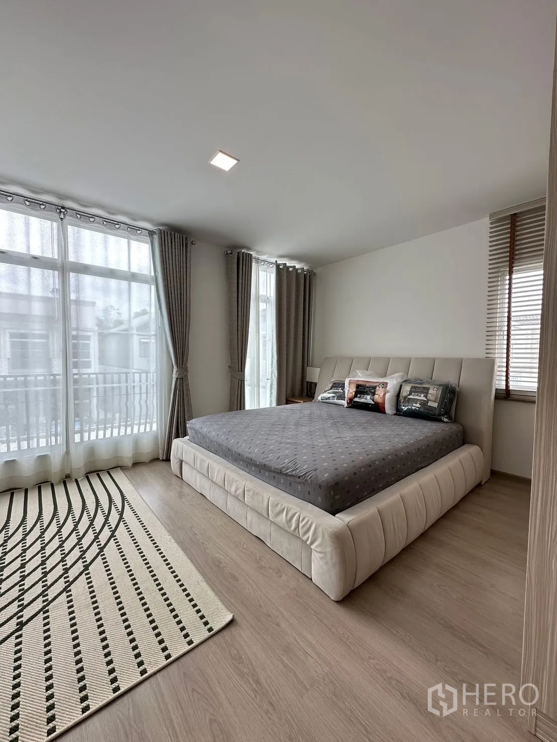 联排别墅 for rent in Prawet, Bangkok - 主卧转角，配置特大床、窗帘与大窗户。