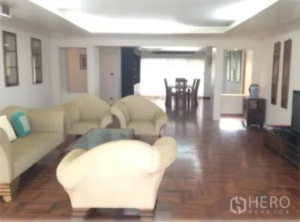 คอนโด ให้เช่าในWatthana, Bangkok - ห้องนั่งเล่นโอเพ่นแพลน โซฟาสีครีม โต๊ะกระจก พื้นปาร์เกต์ เชื่อมสู่ส่วนทานอาหาร