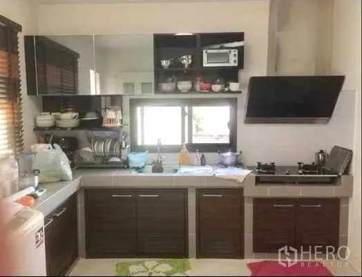 Detached House for sale in Khlong Sam Wa, Bangkok - Functional Thai kitchen with gas hob, range hood and ample cabinets.