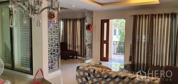 บ้าน ขายในKhan Na Yao, Bangkok - มุมห้องนั่งเล่นพร้อมฉากกั้นลายกระจกและประตูไม้เปิดสู่เฉลียง