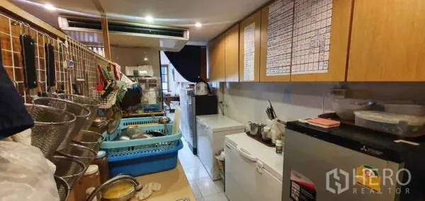 店屋 出租在Khlong Toei, Bangkok - 长形走廊式厨房，挂架、上柜与多台电器