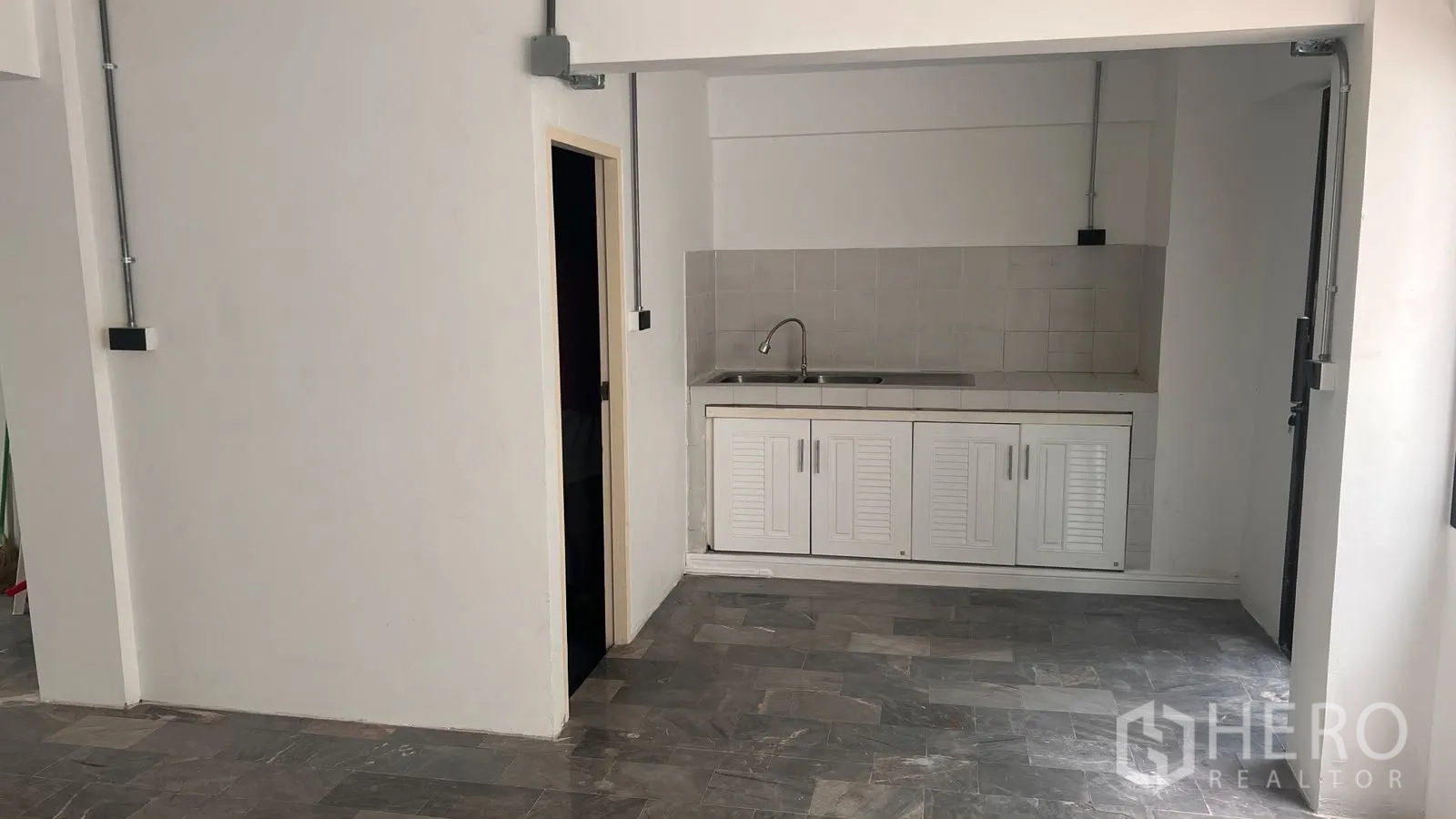 โฮมออฟฟิศ for rent or sale in Phra Khanong, Bangkok - มุมแพนทรี่ตู้บิวท์อินสีขาวพร้อมอ่างล้างจานข้างประตู.