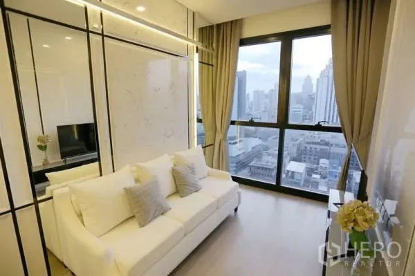 Condominium for rent in Watthana, Bangkok - Bright living room with white sofa, marble accents and floor-to-ceiling windows over the Asoke skyline.