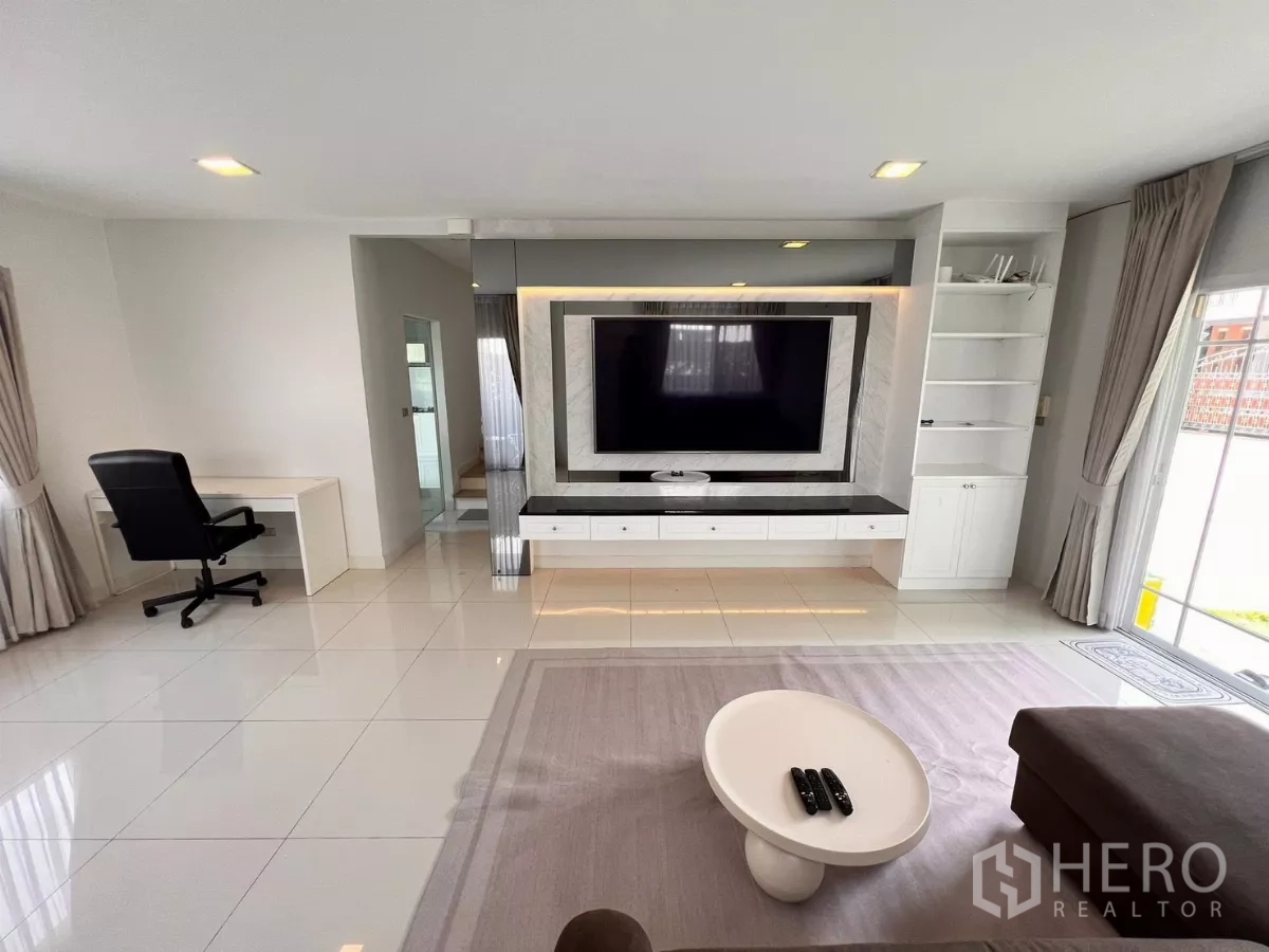 บ้าน ให้เช่าในLat Krabang, Bangkok - โถงนั่งเล่นแบบโอเพ่นพร้อมผนังทีวี มุมทำงาน และพื้นกระเบื้องมันวาว