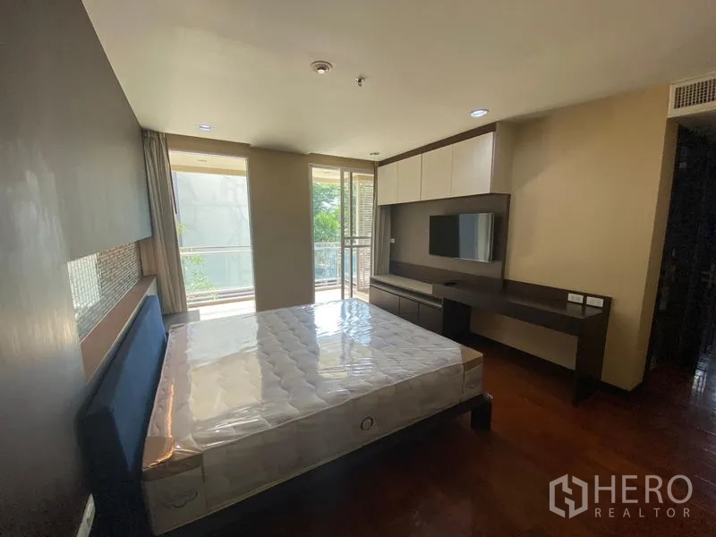 คอนโด ให้เช่าในWatthana, Bangkok - ห้องนอนที่สองมีชั้นวางทีวี บิลท์อิน โต๊ะทำงาน และทางออกสู่ระเบียงวิวต้นไม้