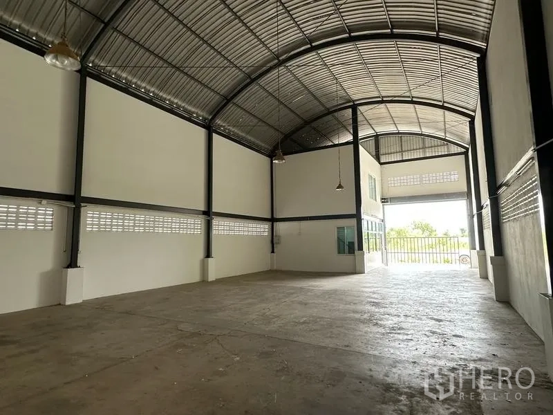 工厂 出租在Bang Bua Thong, Nonthaburi - 车间全景，约8米净高，靠近大开口卷闸门处视角。