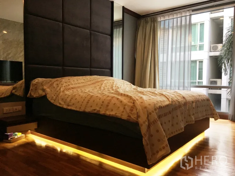 公寓 出售在Khlong Toei, Bangkok - 主卧设软包床头、床下氛围灯与落地窗。